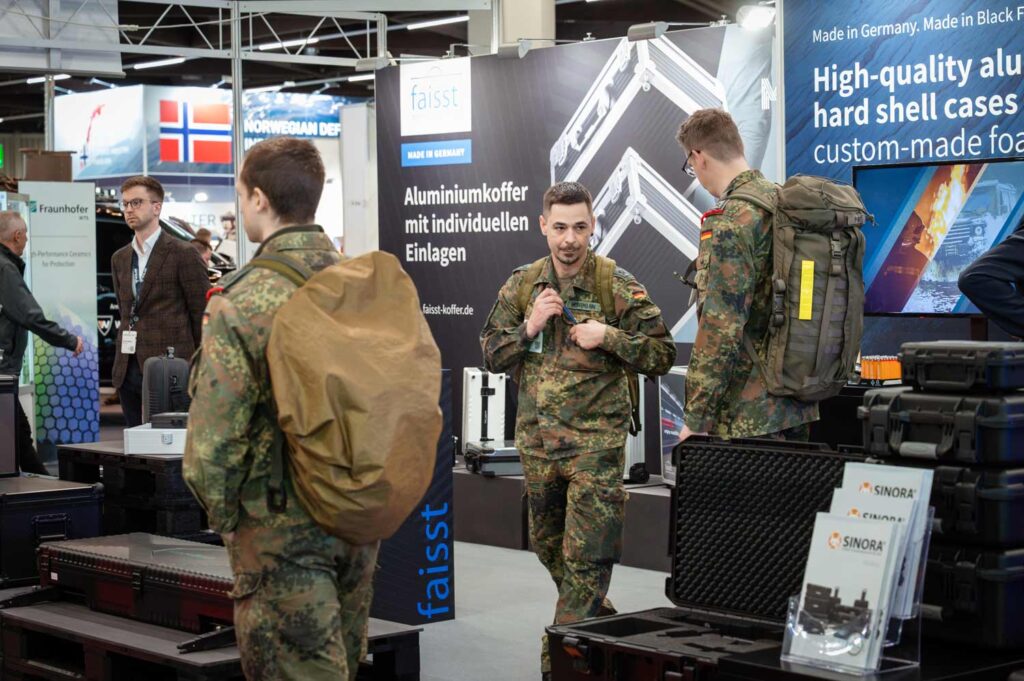 Personen in Feldanzügen auf dem gemeinsamen Messestand von SINORA und Faisst GmbH